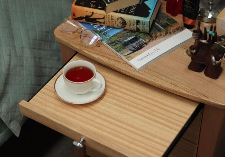Bedside table slide-out breakfast tray with a cup of tea